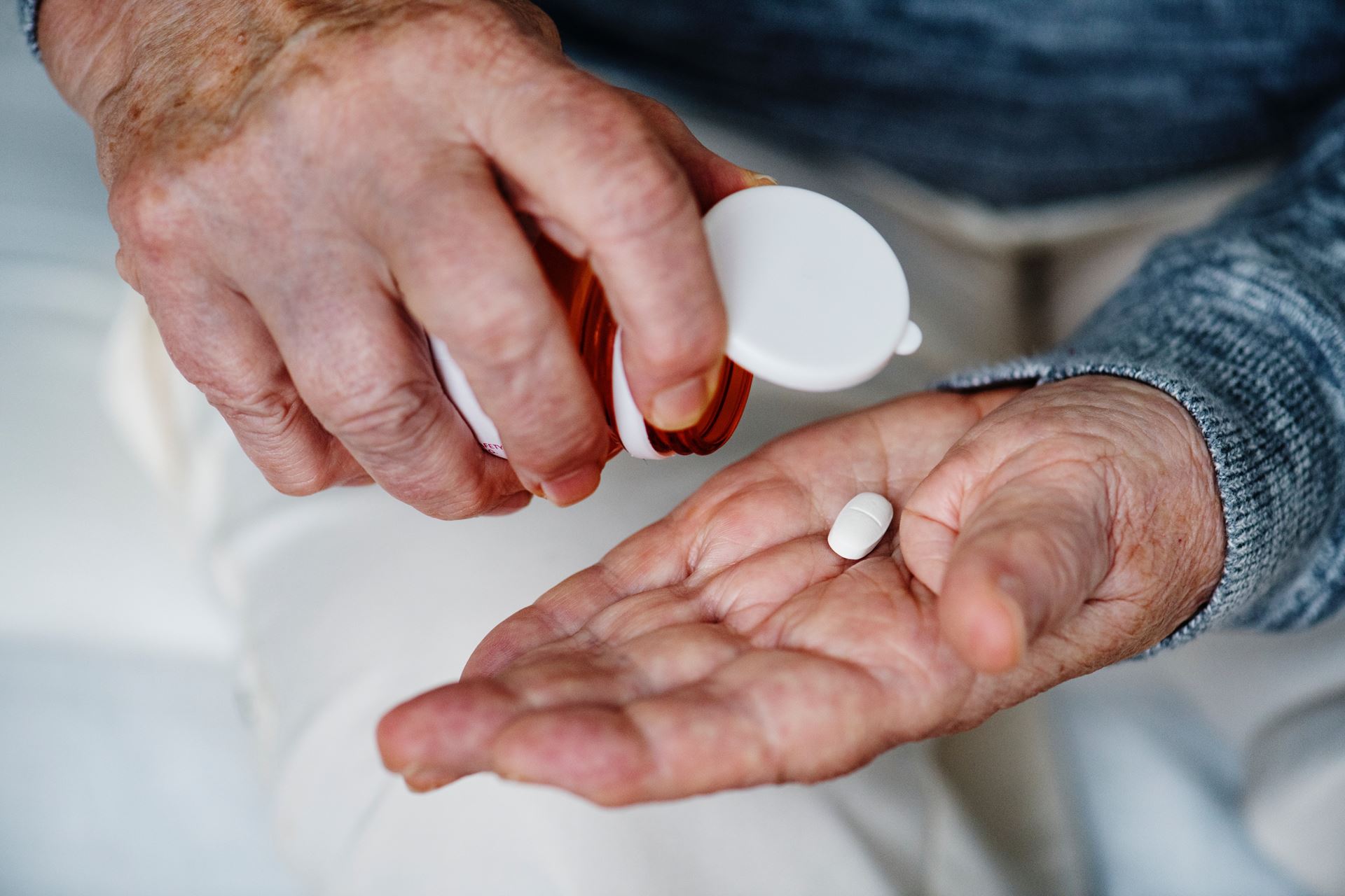 a hand holding a pill